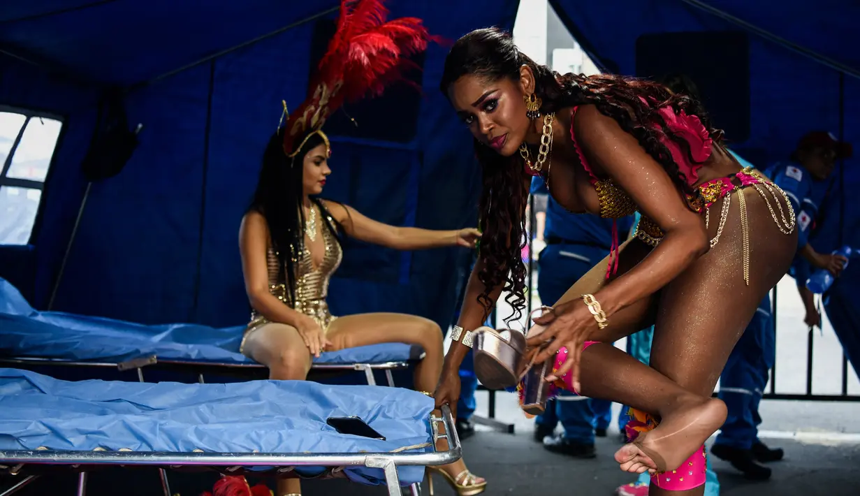 Dua wanita penari salsa Kolombia mempersiapkan diri sebelum tampil dalam pembukaan parade "Salsodromo" Cali Fair ke-61 di Cali, Kolombia (25/12). (AFP Photo/Christian Escobarmora)