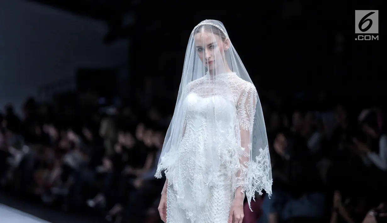 Model berpose diatas catwalk mengenakan karya desainer Cherryn Lim dalam ajang Jakarta Fashion Week 2018 di Senayan City, Jakarta, Kamis (26/10). (Liputan6.com/Faizal Fanani)
