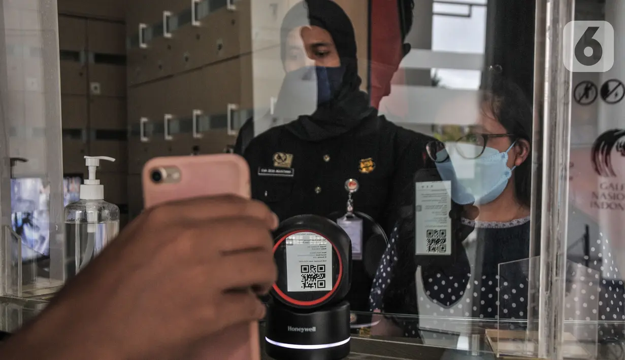 Pengunjung memindai barcode sebagai bukti pendaftaran secara daring sebelum memasuki ruang pameran di Galeri Nasional Indonesia Jakarta, Kamis (28/10/2021). (merdeka.com/Iqbal S Nugroho)