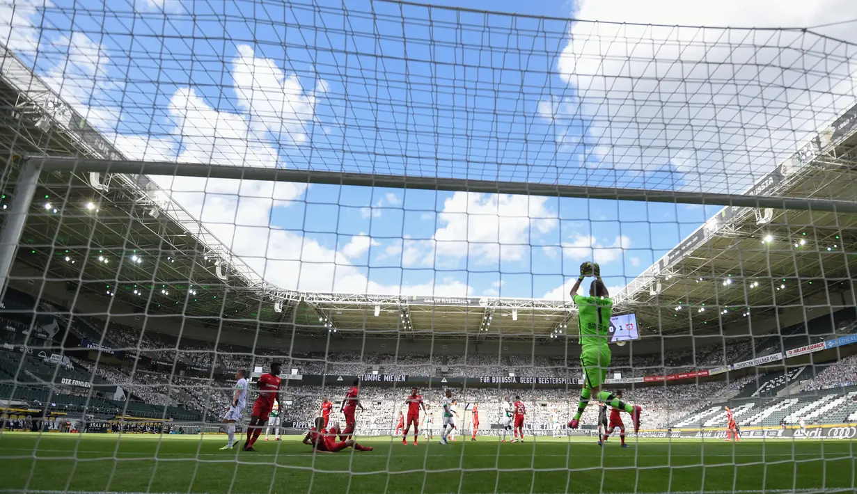 Kiper Bayer Leverkusen, Lukas Hradecky, menangkap bola saat pertandingan melawan Borussia Moenchengladbach pada laga Bundesliga, Minggu (24/5/2020). Bayer Leverkusen menang 3-1 atas Borussia Moenchengladbach. (AFP/Ina Fassbender)