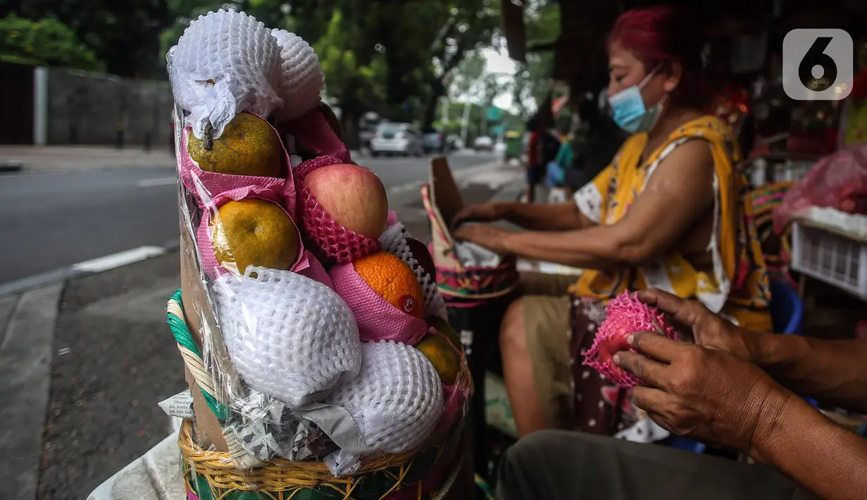 Surayem (58) menyiapkan parcel buah dan vitamin ditoko buah miliknya di Jalan Barito, Jakarta, Minggu (11/7/2021).  Surayem mengaku omset menjual parcel yang dijual secara online meningkat drastis hampir 100 persen dalam sepekan terakhir ini. (Liputan6.com/Johan Tallo)