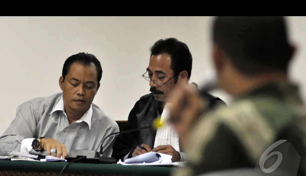 Muhtar Ependi berdiskusi dengan penasehat hukumnya saat menjalani sidang lanjutan di Pengadilan Tipikor, Jakarta, Kamis (15/1/2015). (Liputan6.com/Miftahul Hayat)