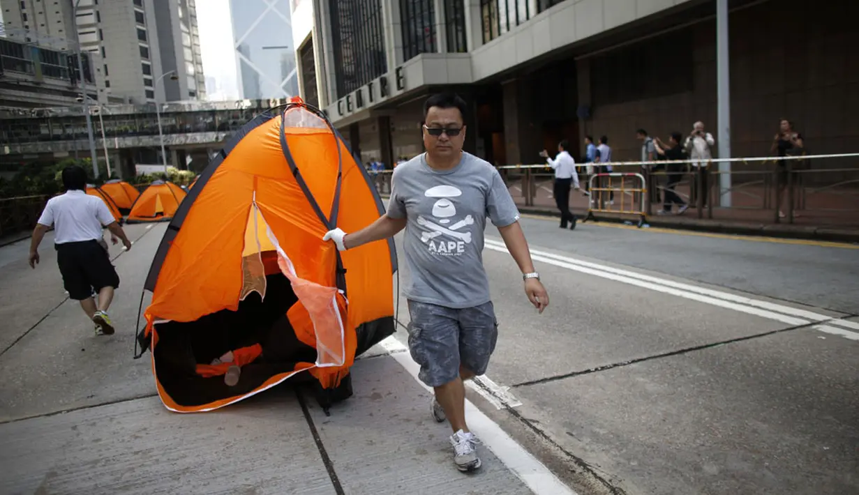 Salah satu anggota kelompok anti-demokrasi menyeret tenda massa pro-demokrasi dari lokasi utama berlangsungnya aksi demonstasi massa pro-demokrasi di Admiralty, Hong Kong, (13/10/2014). (REUTERS/Carlos Barria)