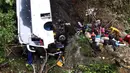 Petugas penyelamat melakukan evakuasi bus yang jatuh di jalan penghubung Medellin dan Bogota dekat San Luis, Provinsi Antiokia, Kolombia, 27 Desember 2021. Tujuh orang, termasuk seorang wanita hamil, tewas dan 20 lainnya luka-luka ketika sebuah bus terjun ke jurang. (Fredy BUILES/AFP)
