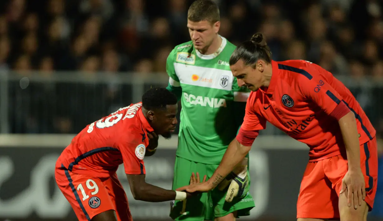 Pemain Paris Saint-Germain, Zlatan Ibrahimovic (kanan) memegang tangan rekannya Serge Aurier (kiri) usai berduel dengan Kiper Angers, Ludovic Butelle  pada lanjutan Ligue 1 di Stadion Jean Bouin, Angers, France. (AFP Photo/Jean Francois Monier)