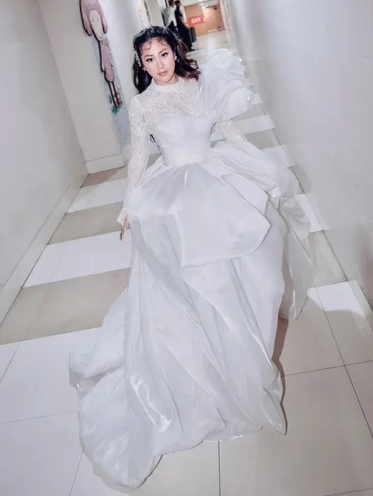 Istri Baskara itu kenakan gaun renda dengan detail drappery yang cantik dari Wirama Pratama.