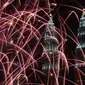 Kembang api menghiasi langit di dekat Menara Kembar Petronas Malaysia saat malam pergantian tahun di Kuala Lumpur, Malaysia. (01/1/2018). Menara Kembar Petronas menjadi salah satu spot para wisatawan menikmati malam tahun baru. (AFP Photo / Mohd Rasfan)