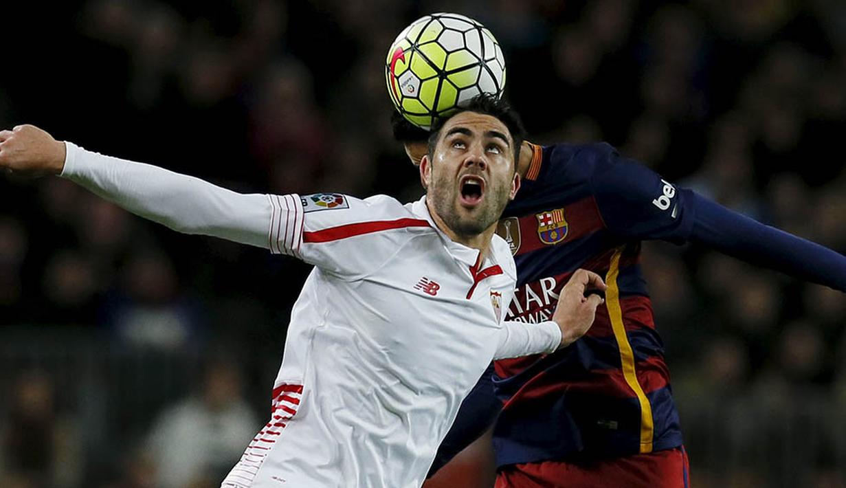 Gelandang Sevilla, Vicente Iborra, duel udara dengan gelandang Barcelona, Sergio Busquets. Pada laga itu Barca sempat tertinggal 0-1 melalui gol Vitolo pada menit ke-20. (Reuters/Albert Gea)