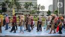 Sejumlah orang yang mengenakan batik berjalan di catwalk sepanjang Jalan Jenderal Sudirman, Jakarta, Minggu (2/10/2022). Kegiatan yang diikuti ratusan orang ini diselenggarakan oleh Bank Mandiri untuk menyambut Hari Batik Nasional yang jatuh setiap tanggal 2 Oktober 2022. (Liputan6.com/Faizal Fanani)