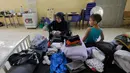 Seorang wanita Lebanon yang mengungsi melipat pakaian di dalam ruang kelas di sebuah sekolah yang menampung para pengungsi Lebanon, di kota Deir Ammar, Lebanon utara, pada 17 Oktober 2024. (Ibrahim Chalhoub/AFP)
