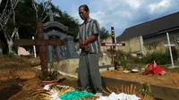 Ayah kandung Fidelis Arie Sudewarto bernama FX Surajiyo saat berdoa di makam Yeni Riawati di pemakaman Katolik di Kabupaten Sanggau, Kalimantan Barat. (Liputan6.com/Raden AMP)