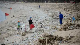 Pemandangan sampah kiriman yang terdampar memenuhi pesisir pantai Kuta, Bali, Kamis (31/12/2020). Pantai Kuta tampak sepi menyusul aturan larangan pesta perayaan pergantian tahun baru dan pemberlakuan jam malam untuk pengendalian aktivitas masyarakat yang dibatasi. (SONNY TUMBELAKA / AFP)