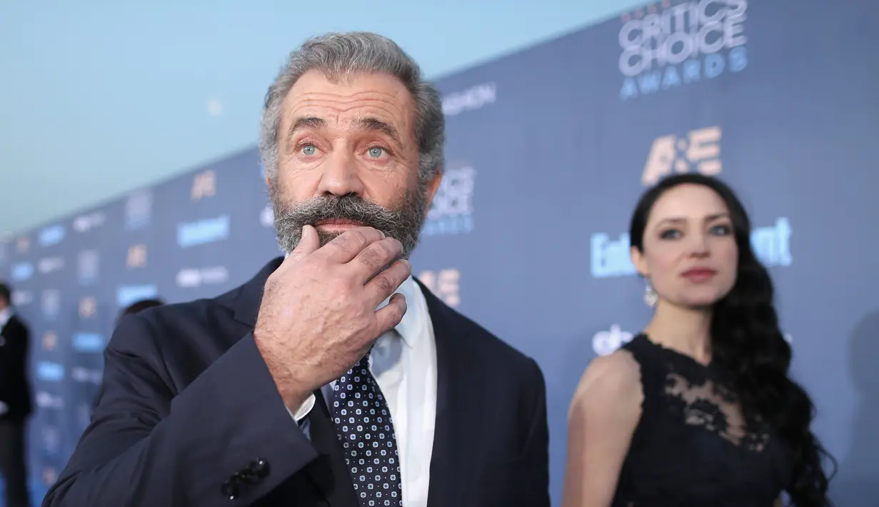 Aktor kawakan Mel Gibson ditemani pacar mudanya, Rosalind Ross menghadiri Critic's Choice Awards 2016 di California, Minggu (11/12). Di acara itu Mel berhasil memenangkan piala Best Action Film dalam film HACKSAW RIDGE. (Christopher Polk/Getty Images/AFP)