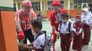 Seniman Aku Badut Indonesia (ABI) mengajarkan anak mencuci tangan di SDN 03 Citayam, Kabupaten Bogor, Jawa Barat, Senin (6/9/2021). Aksi tersebut tentang protokol kesehatan serta membagikan masker kepada anak-anak sekolah yang menggelar Pembelajaran Tatap Muka (PTM). (Liputan6.com/Herman Zakharia)