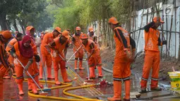 Petugas PPSU membersihkan trotoar di Jalan Asia Afrika, Jakarta, Kamis (2/8). Trotoar yang di pakai para pedagang kaki lima ini di bersihkan guna jelang Asian Games 2018 di Jakarta dan Palembang. (Merdeka.com/Imam Buhori)