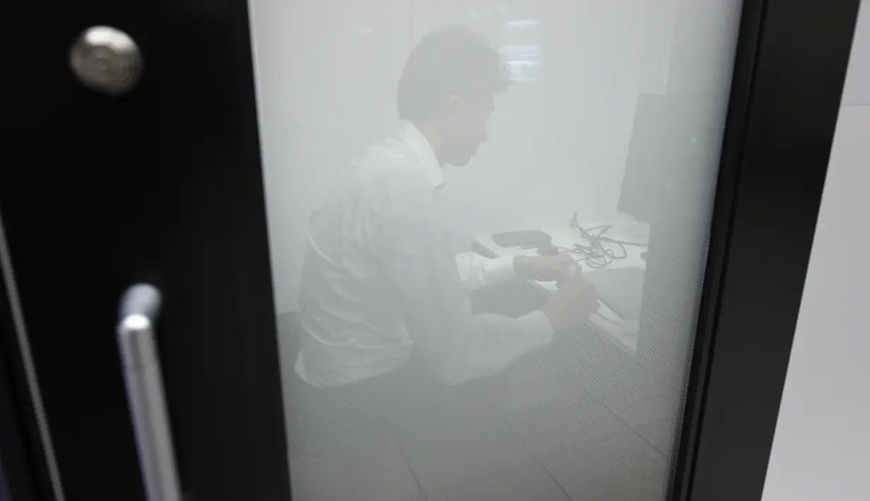Foto 3 Juli 2018, karyawan Fuji Xerox bekerja di sebuah bilik yang dipasang di stasiun kereta bawah tanah Tokyo. Di bilik hitam-putih  ini, para pekerja Jepang bisa melakukan panggilan bisnis tanpa khawatir mengganggu orang lain. (Toshifumi KITAMURA/AFP)
