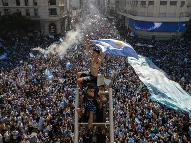 Suporter turun ke Obelisk untuk merayakan kemenangan timnas sepak bola Argentina atas Prancis pada pertandingan final Piala Dunia Qatar 2022 di Buenos Aires, Argentina, 18 Desember 2022. Argentina menang 4-2 dalam drama adu penalti setelah pertandingan berakhir imbang dengan skor 3-3. (AP Photo/Rodrigo Abd)