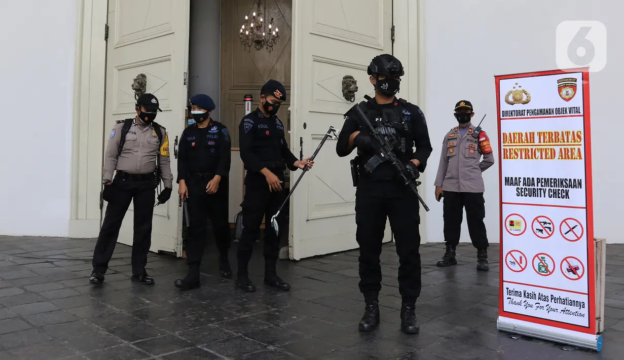 Petugas gabungan berjaga saat melakukan pengamanan dan sterilisasi di sela berlangsungnya misa Jumat Agung rangkaian hari raya Paskah di Gereja Immanuel, Jakarta, Jumat (2/4/2021). Personel TNI-Polri disipakan untuk pengamanan di sejumlah gereja pada perayaan Paskah. (Liputan6.com/Herman Zakharia)