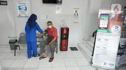 Petugas memeriksa tekanan darah pasien BPJS Kesehatan yang berobat di Faskes Tingkat 1 Klinik Kesehatan Prima Husada di Depok, Jawa Barat, Senin (23/5/20222). Sejumlah terobosan saat ini dilakukan paramedis di Faskes Tingkat 1, diantaranya penilaian peserta program JKN melalui fitur Kessan (Kesan Pesan Peserta Setelah Layanan)  dalam aplikasi Mobile JKN. (merdeka.com/Arie Basuki)