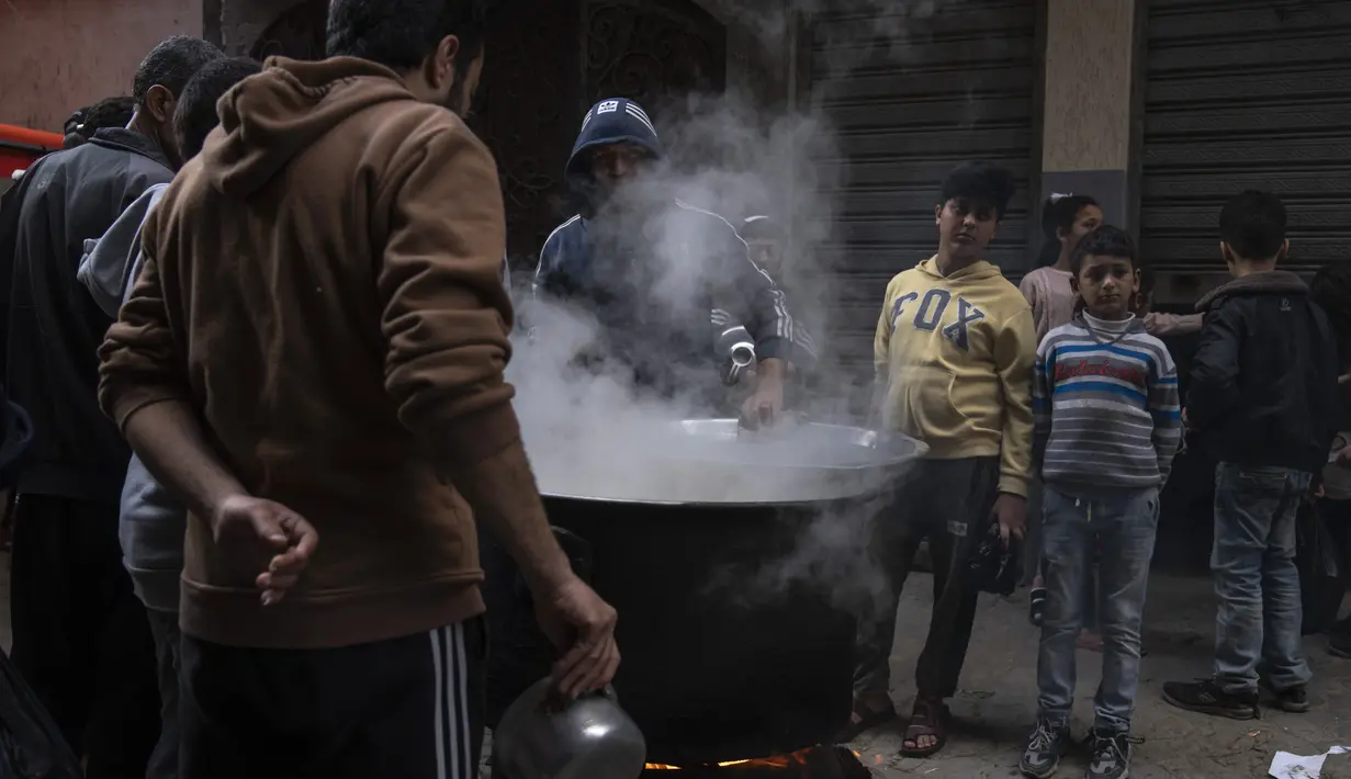 Walid al-Hattab membagikan sup dari panci besar. (AP Photo/Fatima Shbair)