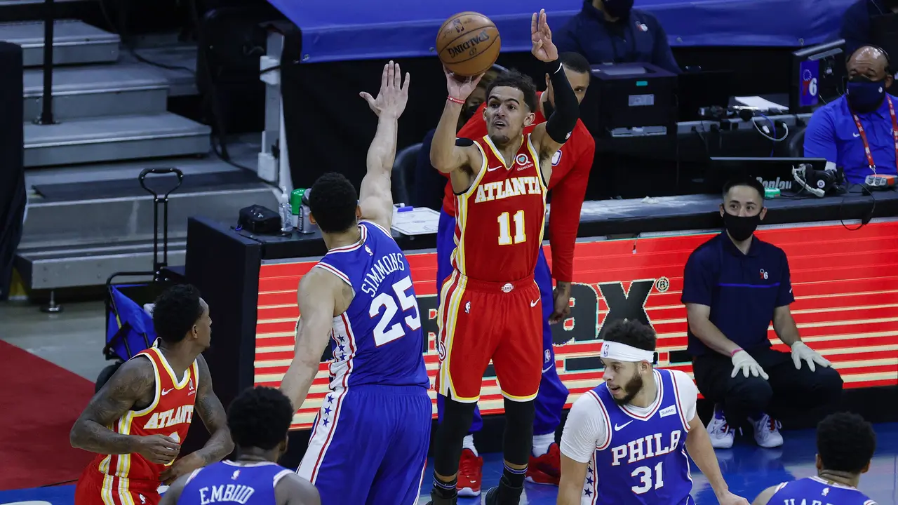 Trae Young melepaskan tembakan di hadapan Ben Simmons