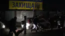 Pengungsi yang melarikan diri dari perang di Ukraina, berjalan di sepanjang jalan mendekati perbatasan dengan Polandia di Shehyni, Ukraina, Minggu (6/3/2022). Jumlah orang Ukraina yang dipaksa meninggalkan negara mereka meningkat menjadi 1,5 juta. (AP Photo/Daniel Cole)