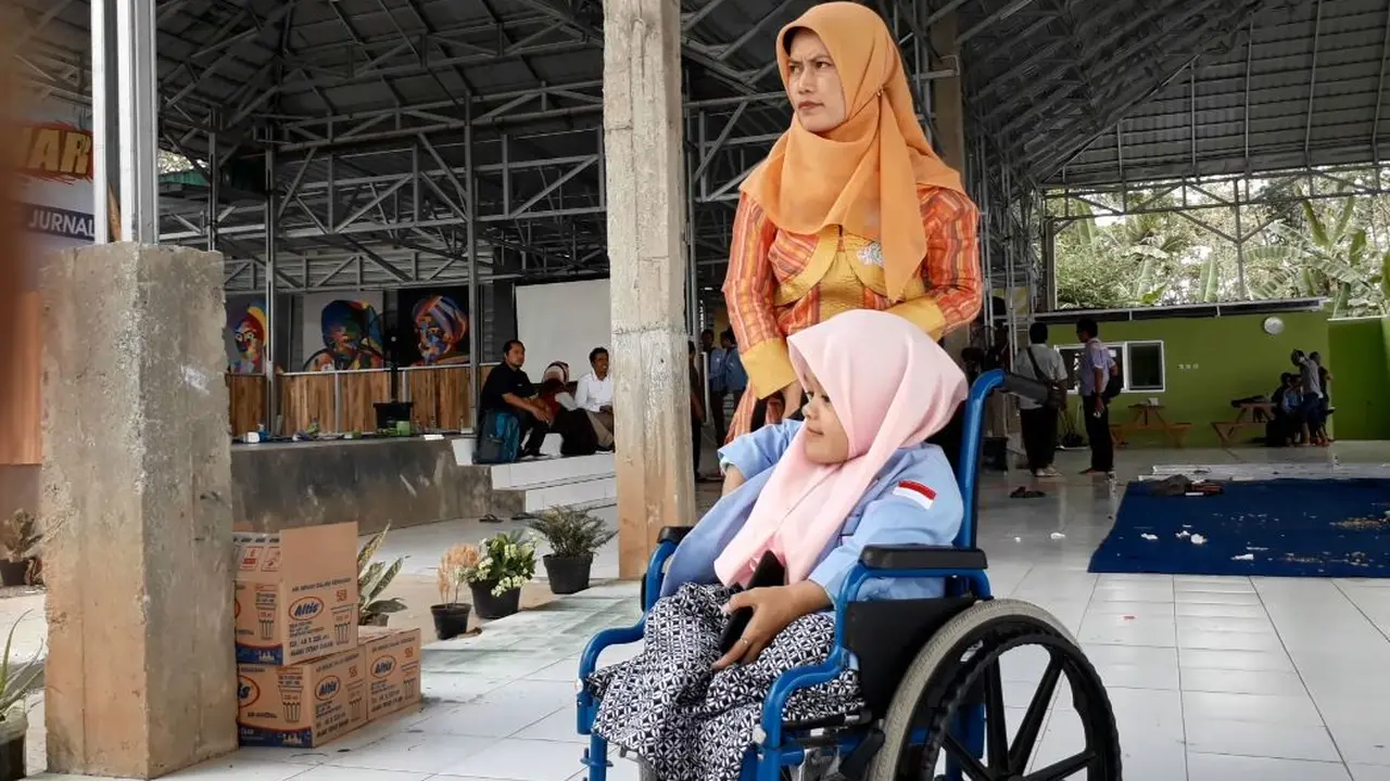 Teti Rohayati (42) warga Sadabumi, Cilacap, sabar antar jemput anaknya yang difabel bersekolah. (Foto: Liputan6.com/Muhamad Ridlo)