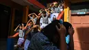 Para siswa melakukan simulasi terkait apa saja yang harus dilakukan ketika sewaktu-waktu terjadi bencana gempa bumi dan tsunami. (CHAIDEER MAHYUDDIN/AFP)