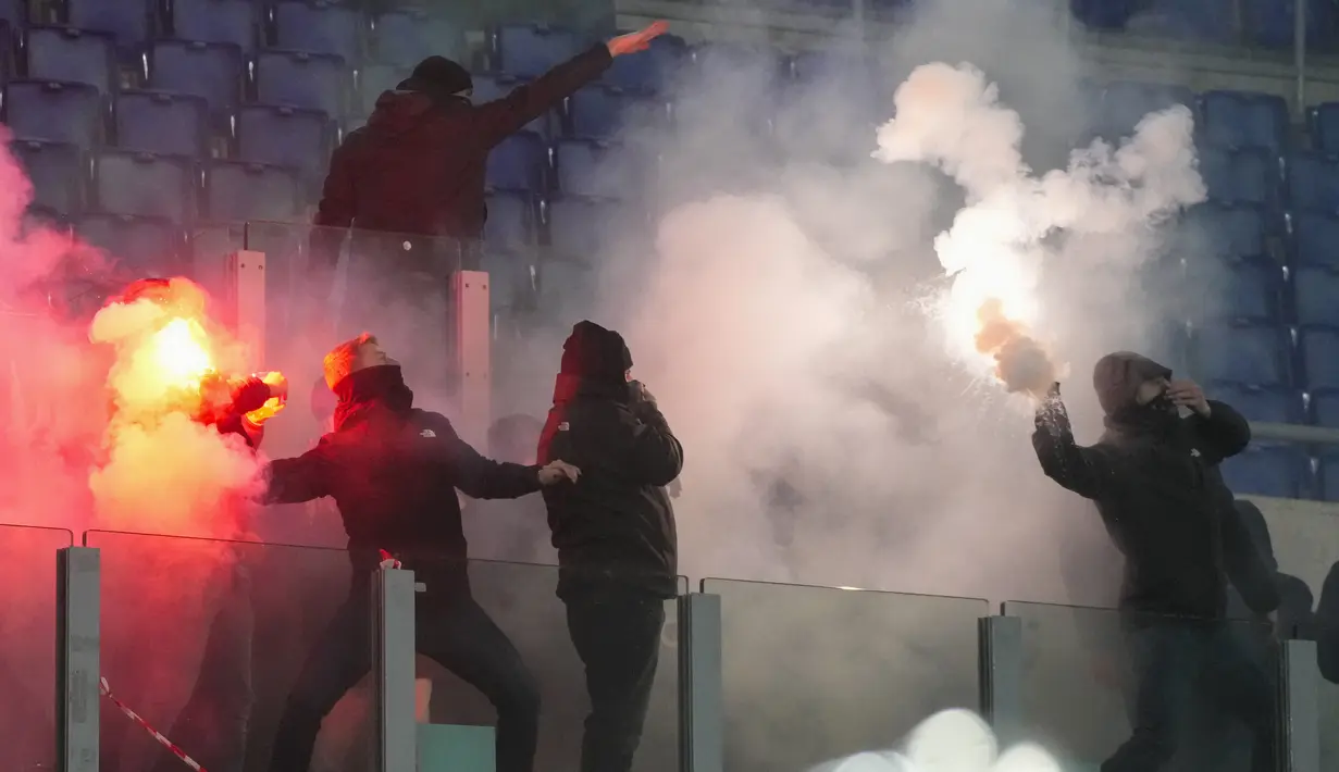 Suporter Lazio dan AS Roma terlibat bentrok sengit dengan saling melontarkan flare di tribun penonton. (AP Photo/Gregorio Borgia)