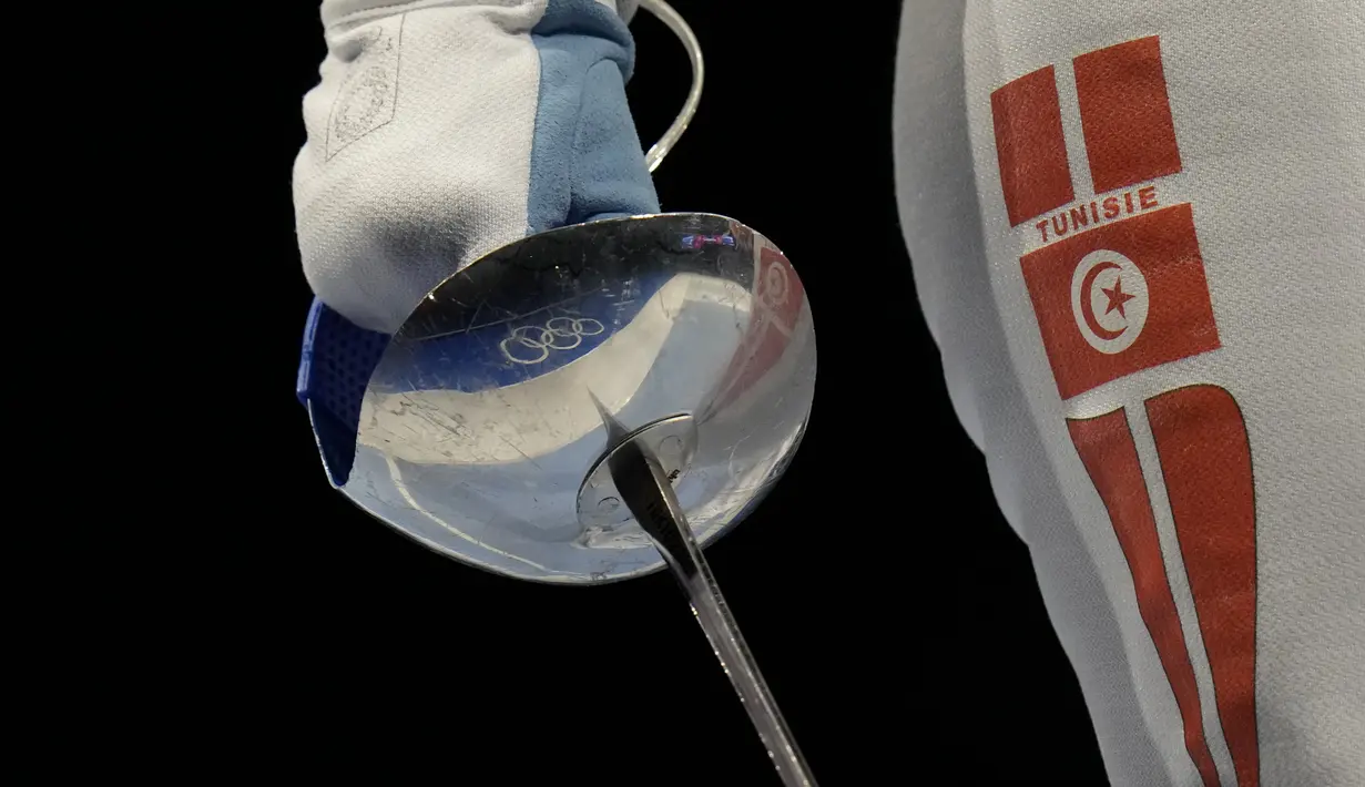 Cincin Olimpiade tercermin pada senjata Sabre Olfa Hezami dari Tunisia saat bersaing dengan Norika Tamura dari Jepang dalam kompetisi babak 16 besar tim Sabre putri di Olimpiade Musim Panas 2020 di Chiba, Jepang (31/7/2021). (AP Photo/Hassan Ammar)