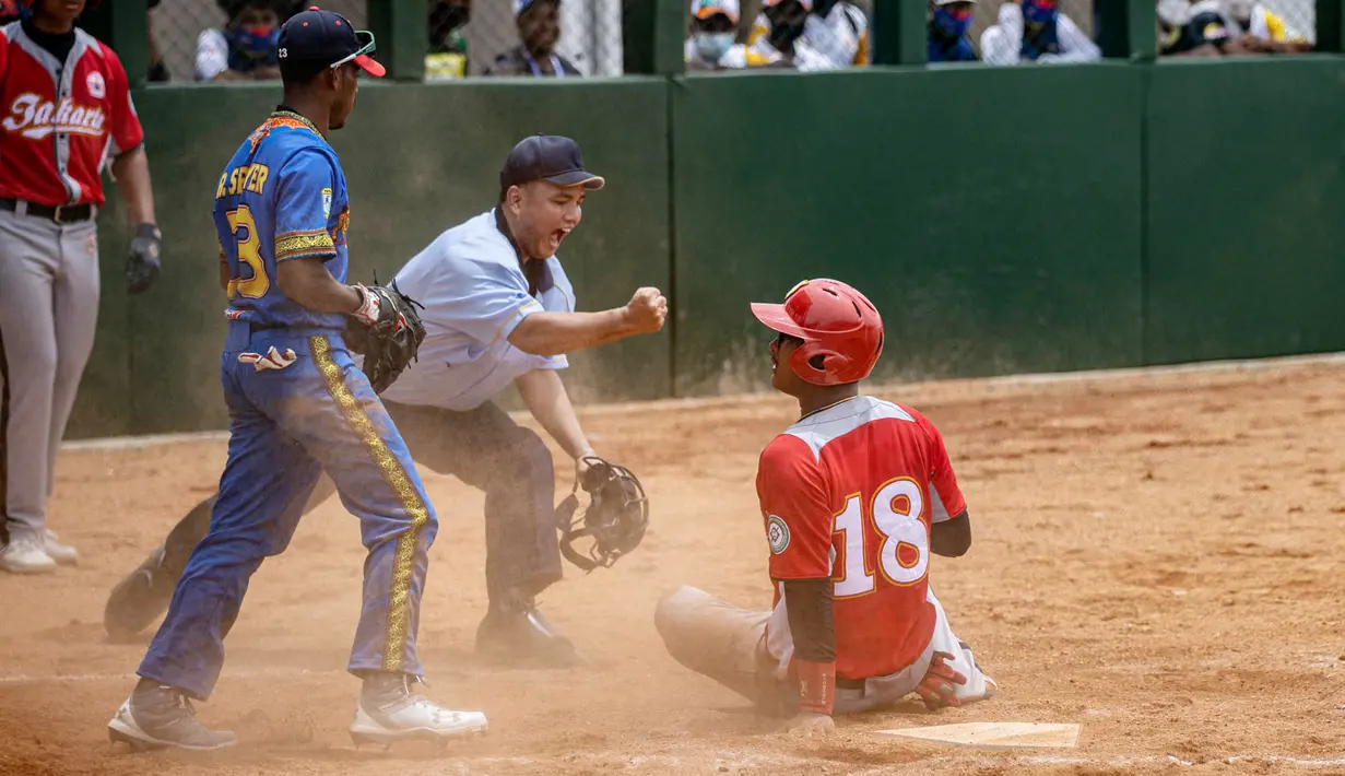 M. Rizki dari DKI Jakarta sliding di home base pada pertandingan kedua babak penyisihan softball putra PON XX Papua antara DKI Jakarta vs Papua Barat di Lapangan Softball Uncen, Kota Jayapura, Rabu (22/09/2021). (Foto : PB PON XX PAPUA/Robertus Pudyanto)