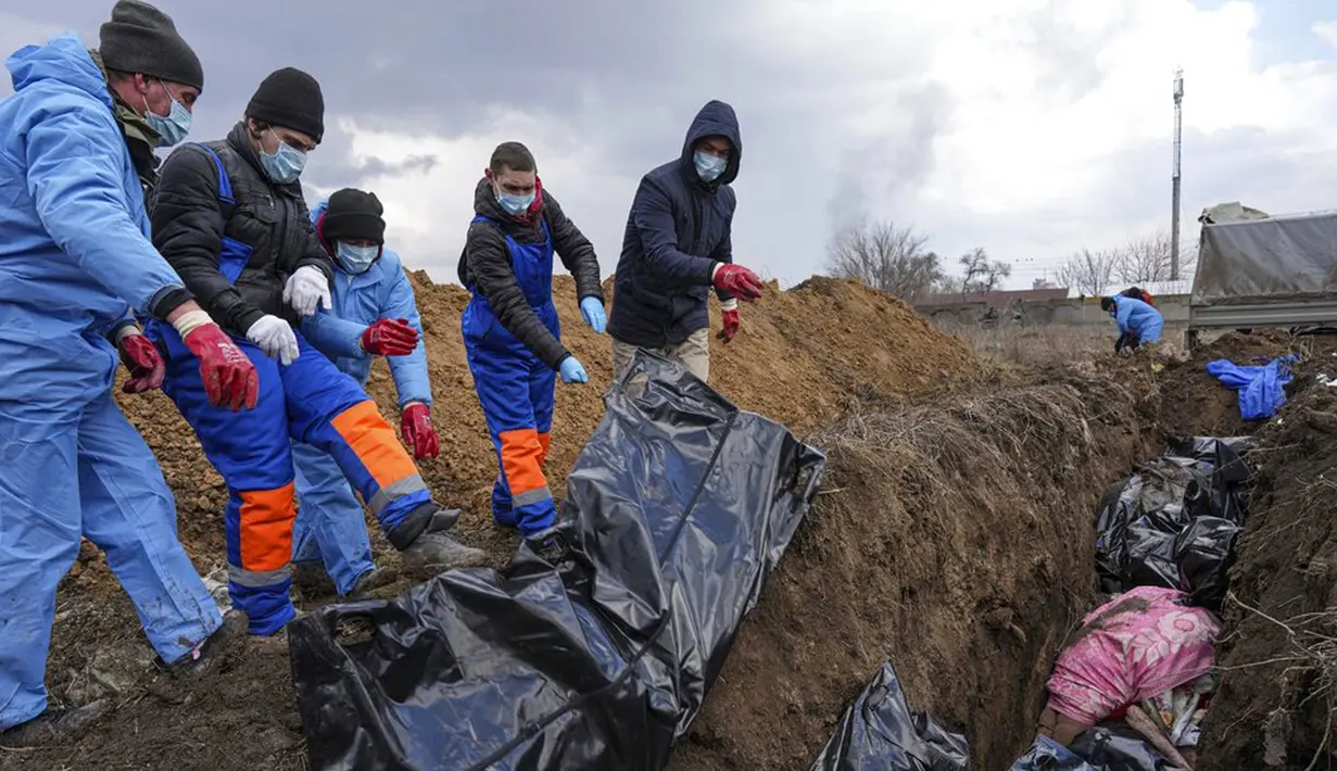 Jenazah ditempatkan pada kuburan massal di pinggiran Mariupol, Ukraina, 9 Maret 2022. Warga tidak dapat menguburkan orang mati di antara mereka karena serangan berat oleh pasukan Rusia. (AP Photo/Evgeniy Maloletka)