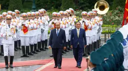 PM Jepang, Yoshihide Suga (kanan) bersama PM Vietnam, Nguyen Xuan Phuc saat upacara penyambutan tamu negara di Istana Kepresidenan, di Hanoi, Vietnam, Senin (19/10/2020). Yoshihide Suga melakukan kunjungan resmi ke Vietnam hingga 20 Oktober 2020. (Kham/Pool Photo via AP)