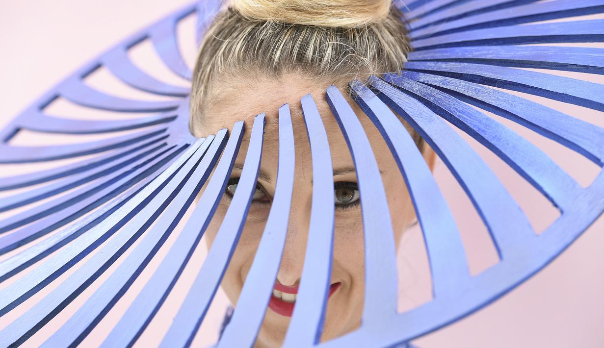 Seorang wanita mengenakan topi unik sebelum pertandingan pacuan kuda Piala Melbourne di Melbourne (5/11/2019). Para wanita tampil cantik dan modis dengan hiasan kepala yang mereka gunakan selama menyaksikan balap kuda di Melbourne Cup.  (AFP Photo/William West)