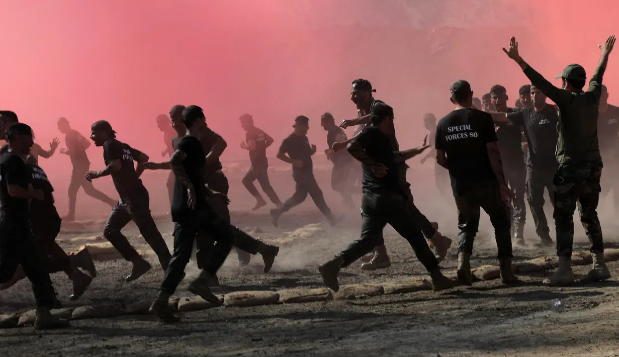 Para perwira Peshmerga melakukan latihan saat mengambil bagian dalam upacara kelulusan di Kota Soran, Irak, Rabu (16/10/2019). Latihan pasukan bersenjata Kurdi tersebut dilakukan sekitar 100 kilometer timur laut ibu kota otonomi wilayah Kurdi di Irak, Arbil. (SAFIN HAMED/AFP)