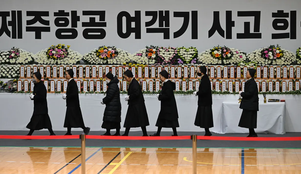 Para pelayat memberikan penghormatan di altar peringatan bagi para korban kecelakaan pesawat Jeju Air, di Muan Sports Park di Muan pada Senin 30 Desember 2024. (JUNG YEON-JE/AFP)