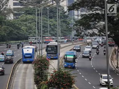 Bus Transjakarta melintas di kawasan Sudirman, Jakarta, Rabu (11/7). Pemprov DKI menyiapkan 1.500 bus Transjakarta untuk mendukung mobilitas warga, atlet, offisial, hingga jurnalis peliput pertandingan Asian Games di Jakarta. (Liputan6.com/Faizal Fanani)