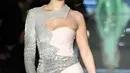 Model AS, Bella Hadid membawakan koleksi terbaru Moschino di panggung runway Milan Fashion Week 2018, Rabu (21/2). Bella Hadid kembali pada nuansa tahun 60-an dengan gaun yang memperlihatkan dua warna antara pink dan silver berkilauan. (Miguel MEDINA/AFP)
