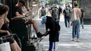 Seorang pria menyemir sepatunya pada hari yang hangat di New York City (7/6/2021). Cuaca yang hangat di New York dimanfaatkan warga untuk membaca buku hingga berjalan-jalan. (AFP/Angela Weiss)