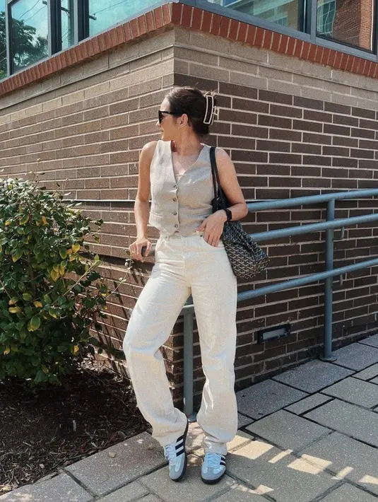 Enzy Storia terlihat begitu stylish dengan wide leg pants dan vest top bernuansa khaki. Gaya fashionnya begitu sempurna dengan sneakers Adidas ikonis. [Foto: instagram/ Enzy Storia]