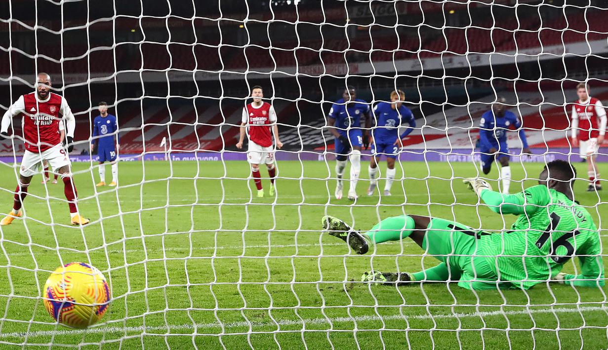 Striker Arsenal, Alexander Lacazette (kiri), mengecoh kiper Chelsea, Edouard Mendy, untuk mencetak gol pertama timnya lewat eksekusi penalti dalam laga lanjutan Liga Inggris 2020/21 pekan ke-15 di Emirates Stadium, London, Sabtu (26/12/2020). Arsenal menang 3-1 atas Chelsea. (AFP/Julian Finney/Pool)