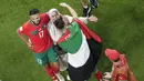 Pemain Maroko, Achraf Daria, merayakan kemenangan atas Portugal bersama keluarganya pada laga perempat final di Stadion Al-Thumama, Sabtu (10/12/2022). (AP/Thanassis Stavrakis)