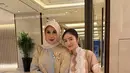 Marini Zumarnis tampil mengenakan long dress coklat dengan aksen biru dihiasi bros emas sambil membawa tas Hermesnya. [@febbyrastanty]