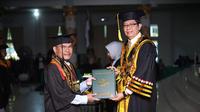 Keterbatasan penglihatan bukan penghalang bagi Supron Ridisno untuk lulus S3, ia menerima ijazah sekaligus dinobatkan sebagai lulusan dengan disertasi terbaik oleh Rektor Uin Lampung. Foto: UIN Lampung.