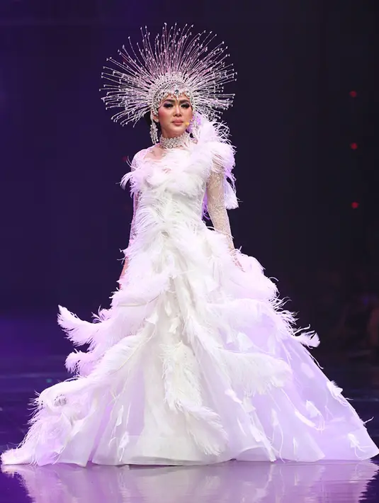 Malam itu, Syahrini menjadi ratu udara dewi angin. Tampil cantik dengan balutan putih berhias bulu-bulu. Di kepala penyanyi asal Bogor itu berhias mahkota. Penampilannya khusus itu dipersembahkan untuk sang Maestro. (Deki Prayoga/Bintang.com)