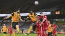 Bek Wolverhampton Wanderers, Willy Boly (tengah) melompat menyundul bola di depan para pemain Liverpool dalam laga lanjutan Liga Inggris 2020/2021 pekan ke-28 di Molineux Stadium, Senin (15/3/2021). Wolverhampton kalah 0-1 dari Liverpool. (AP/Paul Ellis/Pool)