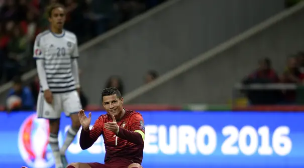 Bintang Portugal Cristiano Ronaldo bertpuk tangan saat terjatuh pada laga Kualifikasi Piala Eropa 2016 Grup I di Municipal stadium, Braga, Kamis (8/10/2015). Portugal menang atas Denmark1-0. (AFP Photo/ Miguel Riopa)