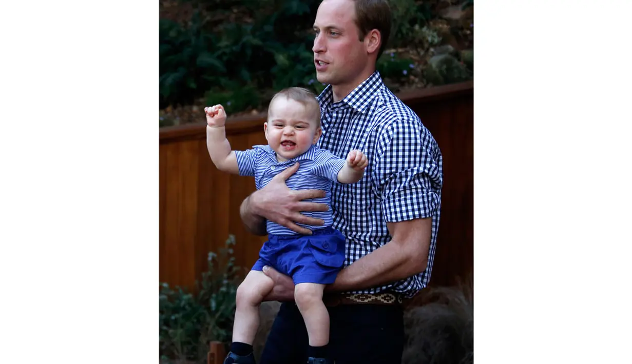 Menggunakan kemeja biru, celana pendek lengkap dengan sepatu biru tua, George terlihat begitu menggemaskan dan membuat Pangeran William nampak kewalahan saat menggendongnya, (20/4/2014). (REUTERS/David Gray)