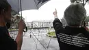 Keluarga korban pelanggaran HAM menunjuk Istana Negara saat 'Aksi Diam Kamisan'. Aksi ini telah memasuki tahun ke delapan, Jakarta, Kamis (22/1/2105). (Liputan6.com/Herman Zakharia)