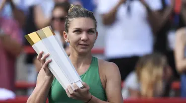 Petenis Rumania, Simona Halep memegang trofi Kanada Terbuka 2018 setelah menaklukkan petenis AS, Sloane Stephens di IGA Stadium, Montreal, Minggu (12/8). Halep menyudahi laga dengan kedudukan 7-6 (8-6), 3-6, 6-4. (Minas Panagiotakis/Getty Images/AFP)